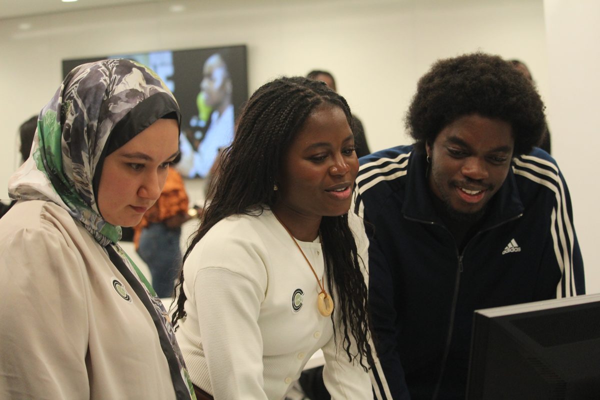 Three people looking at the CompCrafter platform on a screen together